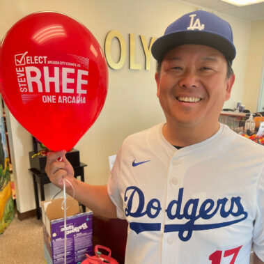 Steve Rhee holding a red balloon with Elect Steve Rhee for City Council.