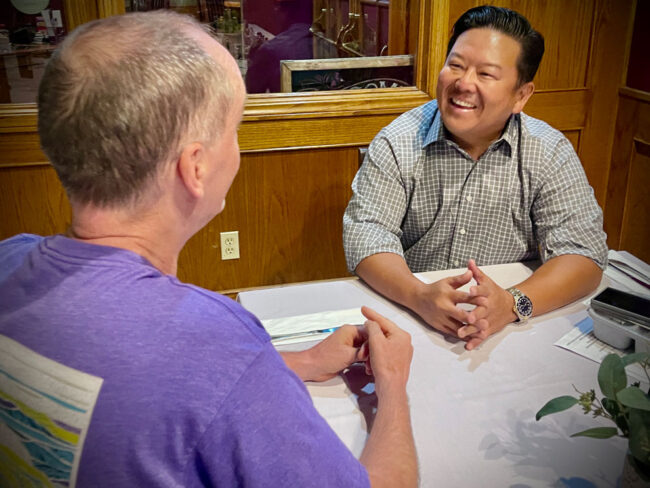 Steve Rhee talking a resident man at a restaurant.