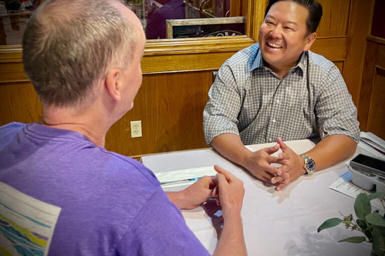 Steve Rhee talking a resident man at a restaurant.