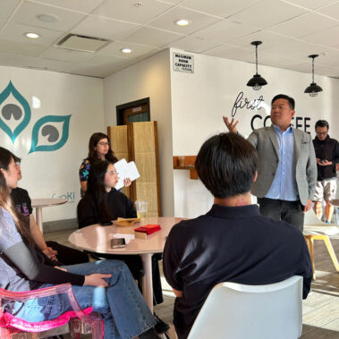 Steve Rhe at Goki Cafe talking to a group of people.