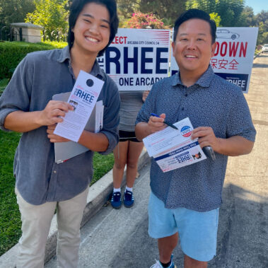 With a resident smiling holding a voting card.