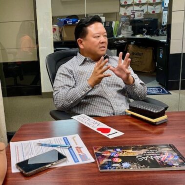 Steve Rhee sitting a table talking.