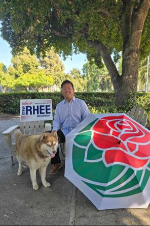 Steve Rhee 4 Arcadia sitting with his dog with Rose Parade umbrella.